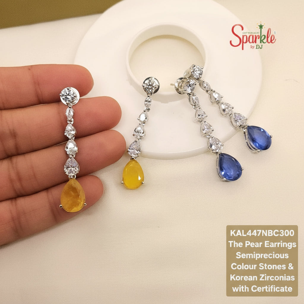 Two pairs of pear-shaped earrings with yellow and blue stones held by a hand, branded 'SparklebyDJ'.