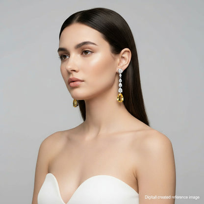 Pair of drop earrings with yellow gemstones and clear stones on a light gray background