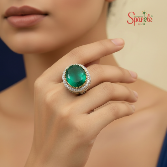 Close-up of a hand wearing a green gemstone ring with 'SparklebyDJ' branding.