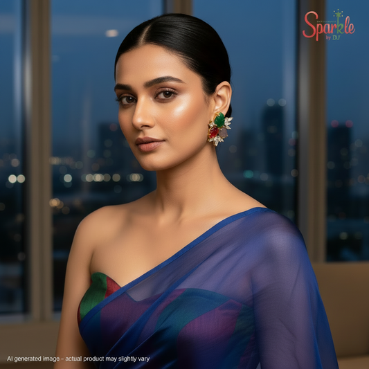 Pair of earrings with colorful stones on a beige fabric background, branded 'Sparkle by DJ'.