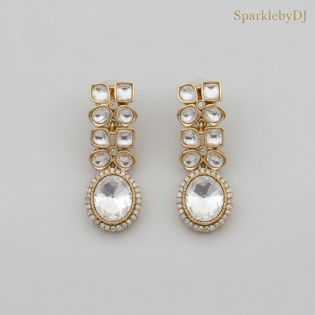 Gold and crystal earrings on a beige background with 'SparklebyDJ' branding.
