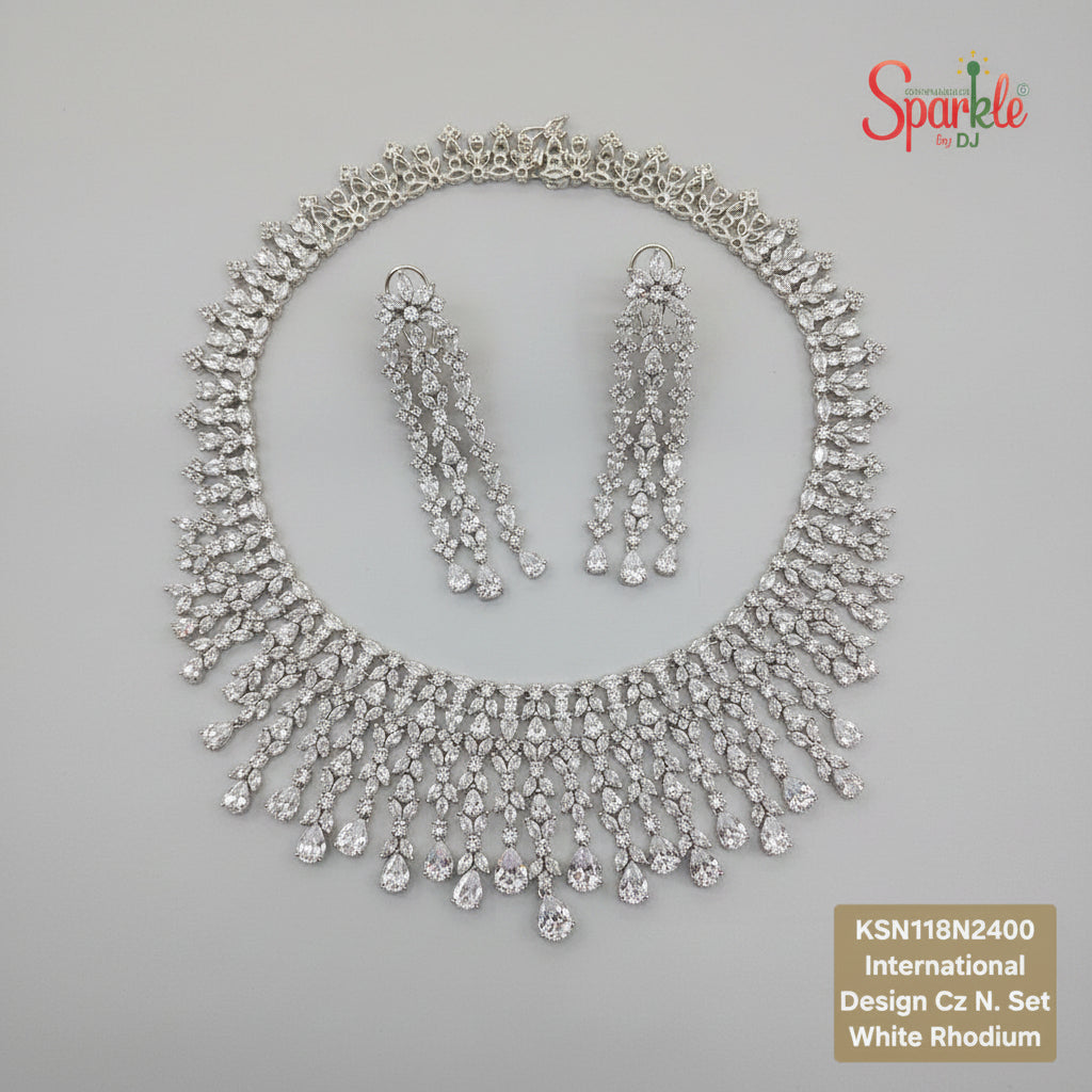 Silver necklace and earrings set on a beige surface 