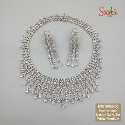 Silver necklace and earrings set on a beige surface 