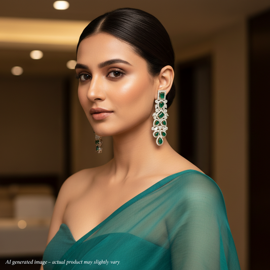 Woman wearing a teal saree with green and silver earrings indoors.