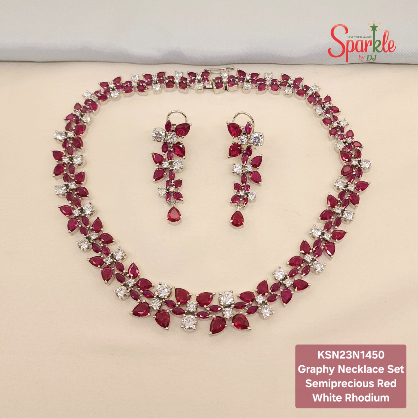 Graphy necklace set with semiprecious red and white stones on a beige surface, branded 'SparklebyDJ'.