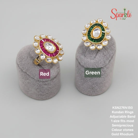 Two Kundan rings, one red and one green, on gray stands with 'SparklebyDJ' branding.