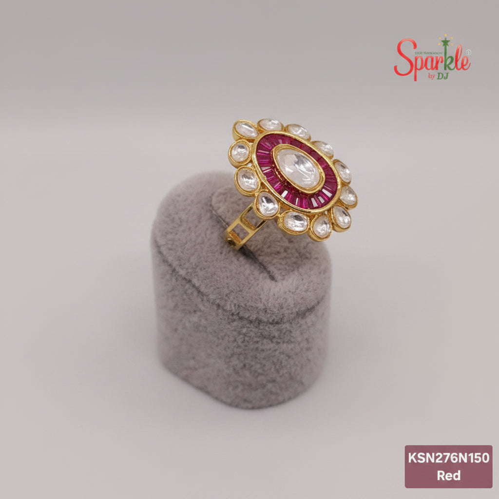 Decorative ring with pink gemstone and gold accents on a gray cushion, branded 'SparklebyDJ'.