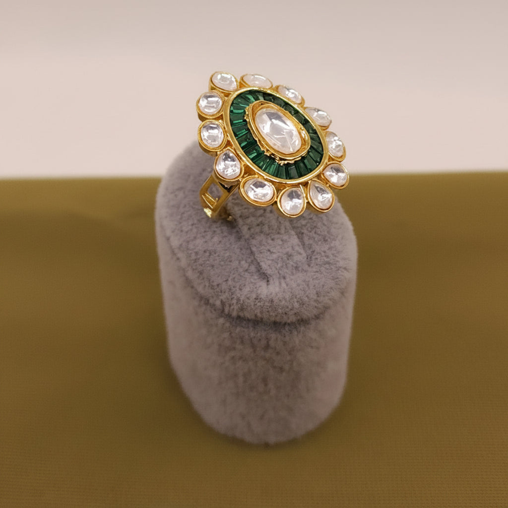 Decorative ring with green and gold design on a gray stand, brand 'SparklebyDJ' visible.