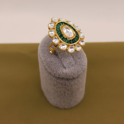 Decorative ring with green and gold design on a gray stand, brand 'SparklebyDJ' visible.