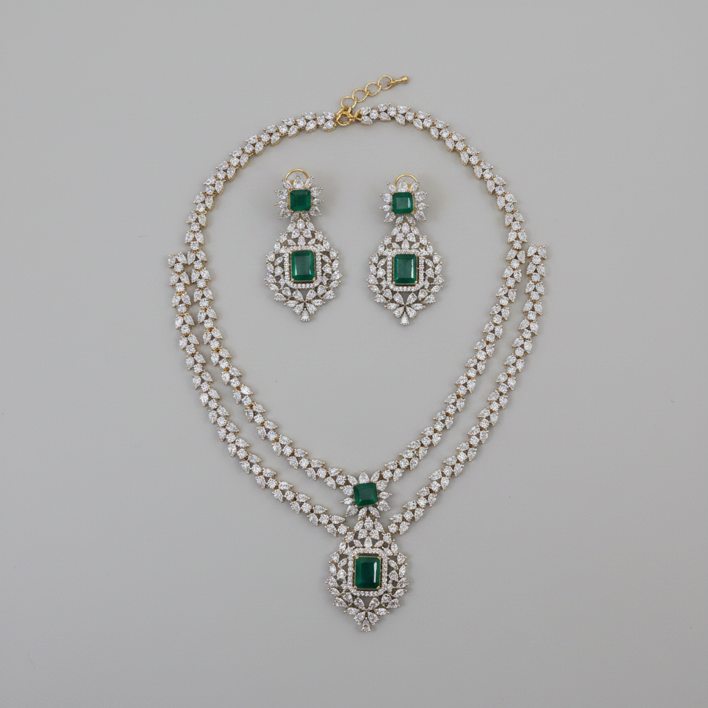 Jewelry set with necklace and earrings featuring green gemstones on a gray background