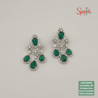 Green gemstone earrings with silver accents on a beige surface, branded 'SparklebyDJ'.