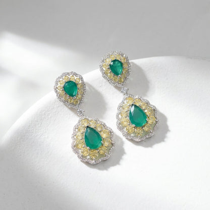 Stylish green doublet earrings on white textured surface, spotlighting micro-details and luxurious design in natural light.