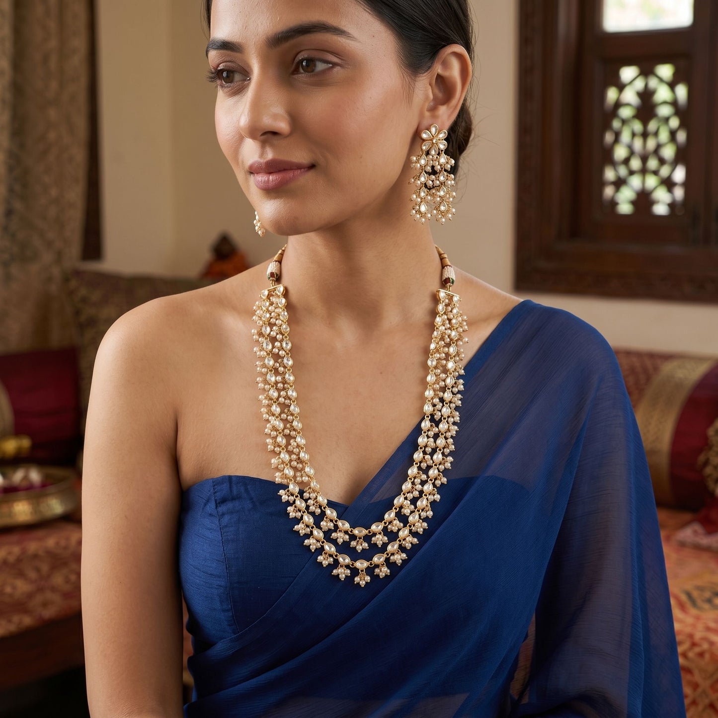 Elegant traditional Kundan and pearl multilayer necklace set on an Indian model in a saree, showcasing intricate craftsmanship and regal design.